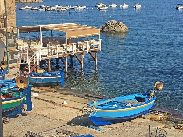 Barcas de pesca y terrazas sobre el mar en Chianalea